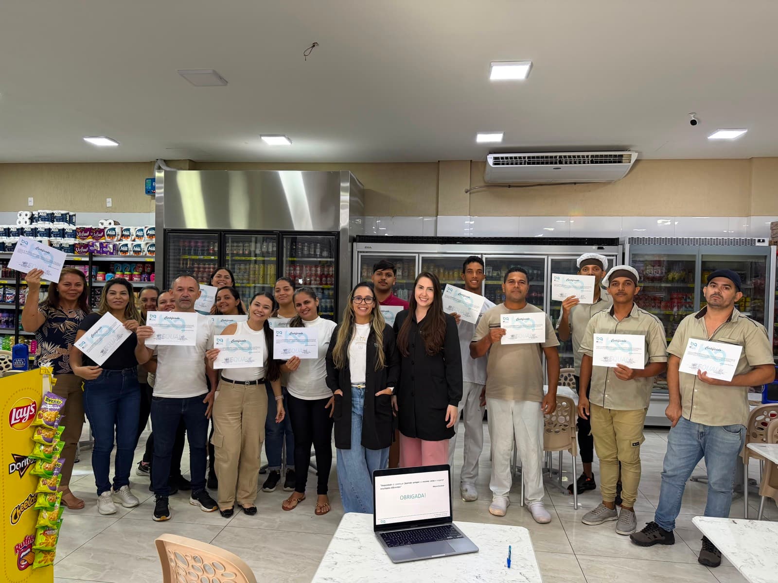 Equipe de padaria e mercado com os certificados de treinamento, com a apresentação encerrada ao fundo